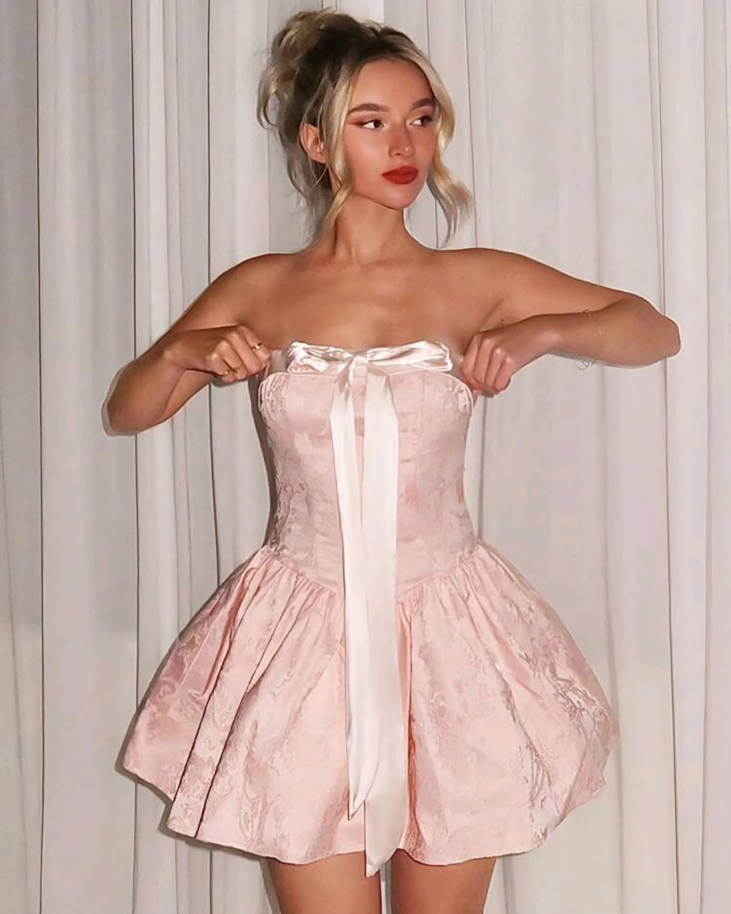 Vestido corto rosado abombado con lazo blanco